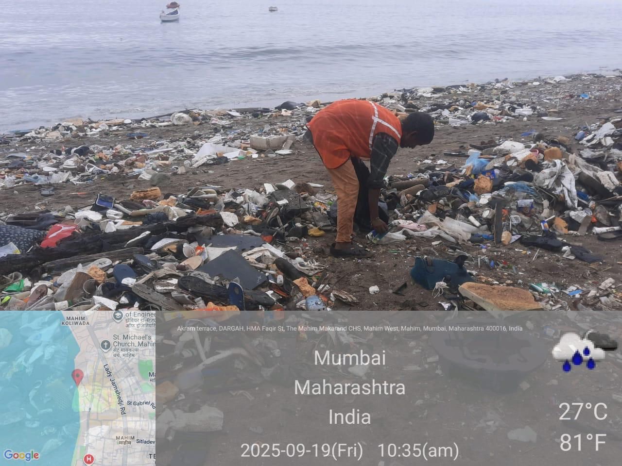 A waste-picker collecting plastic on the shore at Mahim